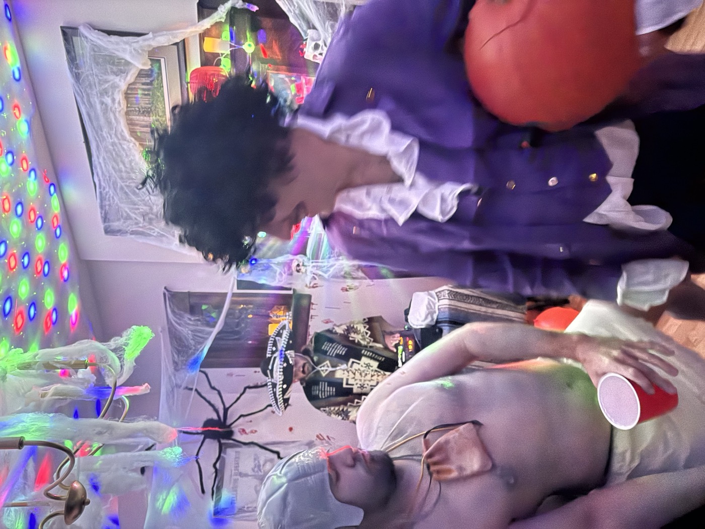 Guests dressed as Prince, a toga-wearer, and a mariachi under disco lights